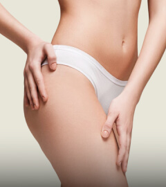 A close-up view of a woman's buttocks, elegantly showcased in white underwear against a neutral background.